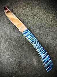 Mammoth tooth inlay knife with stabilized fossil handle material, showcasing natural prehistoric patterns and rich earthy tones, crafted for custom knifemaking and collectors