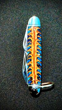 Knife with pinecone in resin handle, featuring a stabilized natural pinecone embedded in clear resin with intricate organic texture, ideal for custom knifemaking and unique handle designs