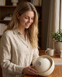 Frau im Wohnzimmer mit der Design-Vase Velum in der Hand