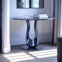 Winston console table with Titanium Black stainless steel base and premium white stone top, styled as an entryway console in a modern living room with contemporary decor, wall art, curtains, books, and a decorative candle