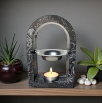 Wax Melt, Essecntial Oil Arch shaped burner, black marble effect design, lit tea light to base. resting on a shelf with a few plants