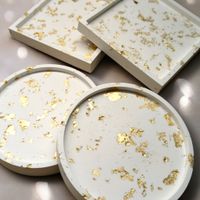 4 coasters, 2 round and 2 square with with gold fleck design resting on a white background