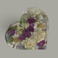 a heart shaped ornament created from resin showcasing preserved flowers