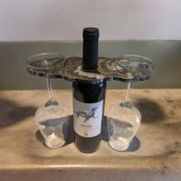 a geode design wine tidy storing two glasses of wine resting over a wine bottle.