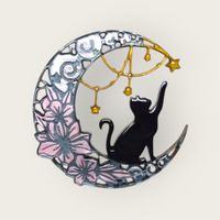 crescent moon shaped decoration depicting a black cat reaching for the stars. Pastel colours to the design