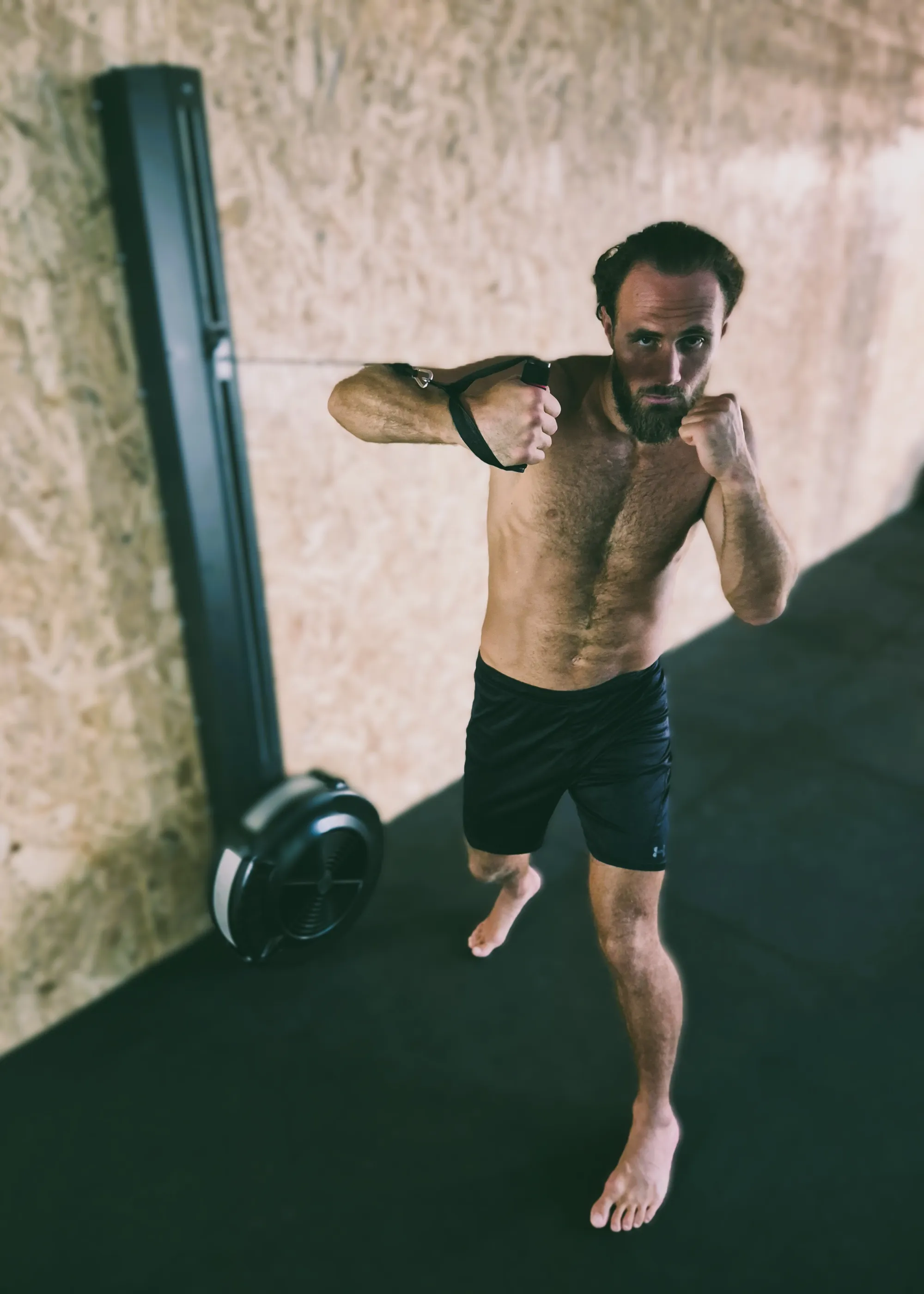 Boxing punch technique showing a hook punch in a gym setting with training equipment. Do not generate human shapes.