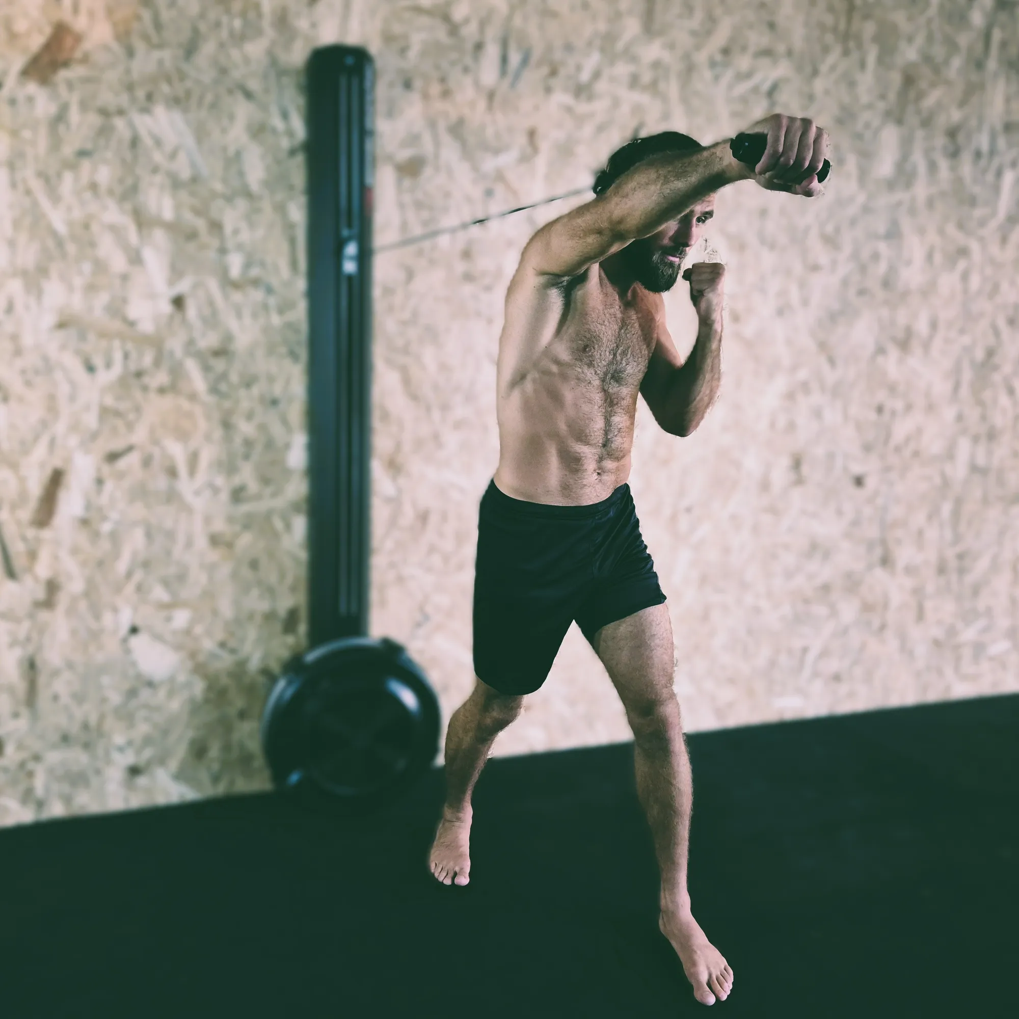 Boxing punch technique showing a cross punch in a gym setting with training equipment. Do not generate human shapes.