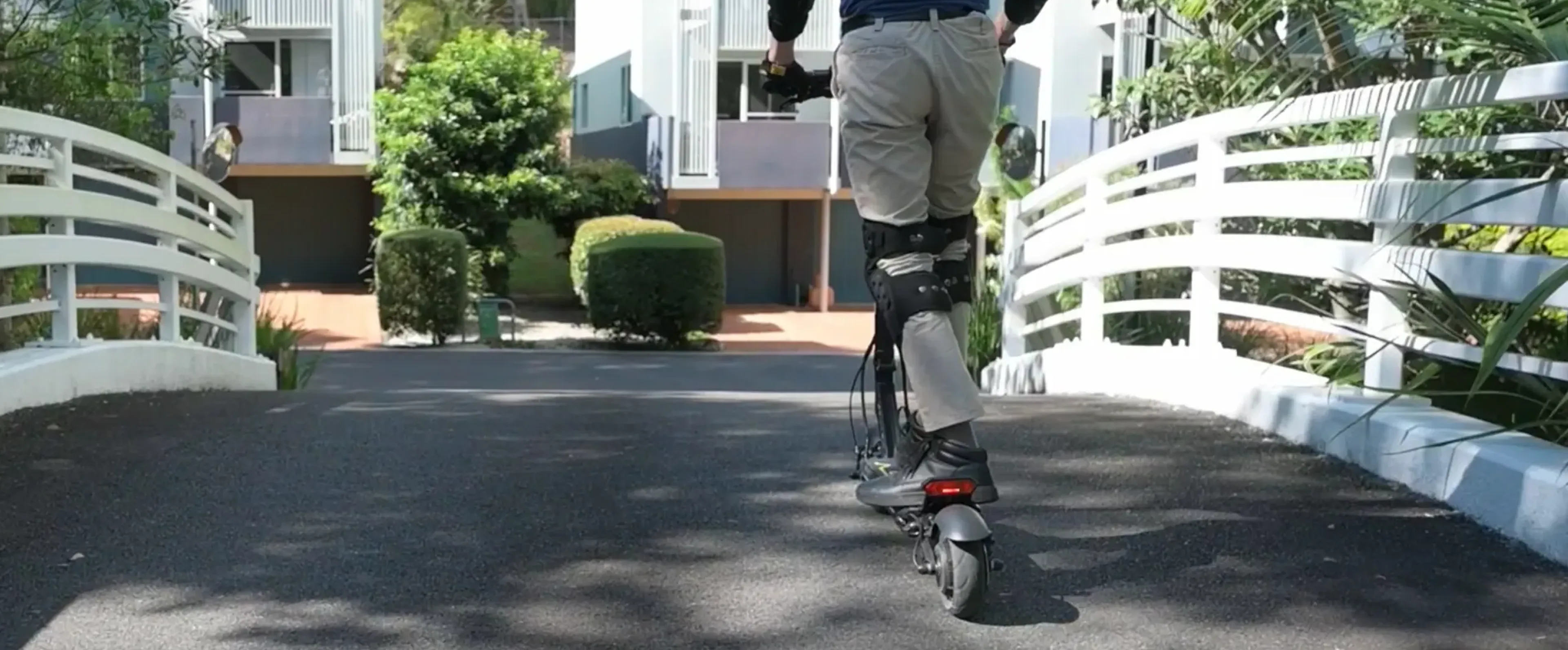 Electric scooter in a garage or workshop setting with green LED lights. No humans should be visible in this image.