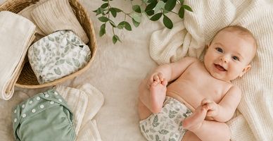 freundlich lächelndes Baby in Stoffwindeln